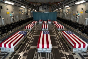 Flag-draped transfer cases line the inside of a C-17 Globemaster II prior to a dignified transfer