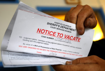 FILE PHOTO: Vicente Oliveros holds up his eviction notice in Los Angeles