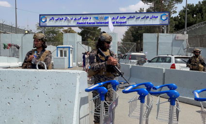 Taliban forces stand guard at the entrance gate of Hamid Karzai International Airport a day after U.S troops withdrawal in...