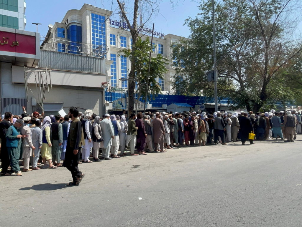 Afghans line up outside a bank to take out their money after Taliban takeover in Kabul