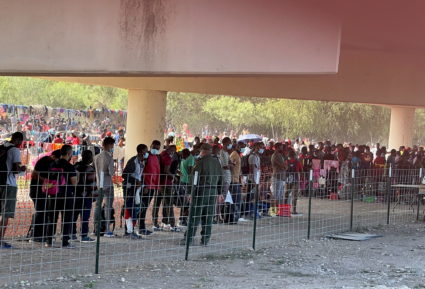 Migrants stand by the International Bridge between Mexico and the U.S., in Del Rio