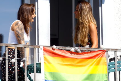 Young lesbian couple talk on their balcony in Zurich