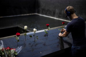 A man places roses at the 9/11 Memorial ahead of the 20th anniversary of the September 11 attacks in Manhattan, New York C...