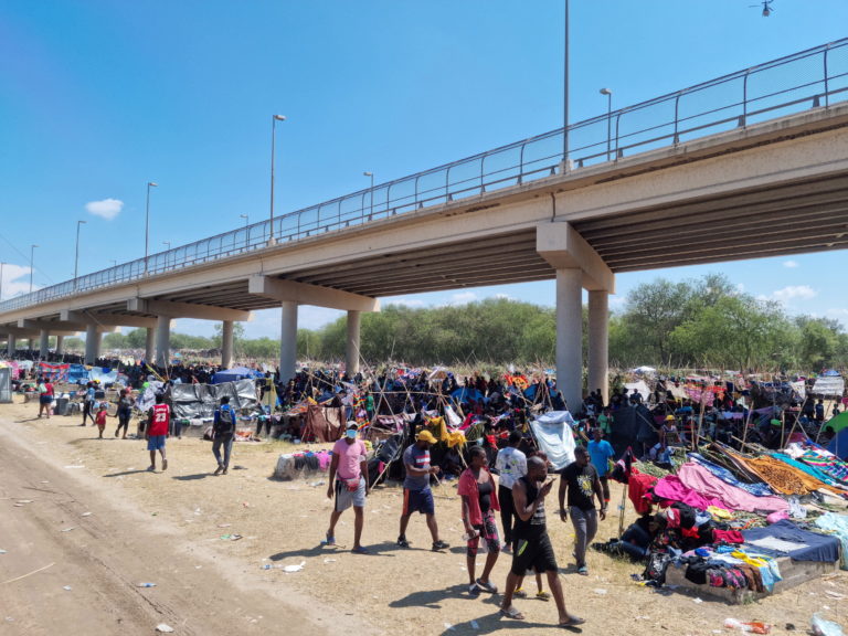 Migrants shelter under the Del Rio International Bridge which connects with Mexico