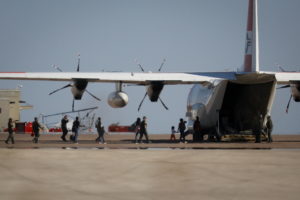 Migrants board a U.S. Coast Guard airplane at the Del Rio International Airport as U.S. authorities accelerate removal of ...