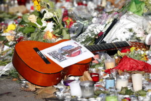 A guitar with a message bearing France's national motto "Liberte, Egalite, Fraternite", is seen among flowers left in trib...