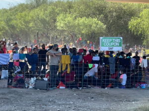 Migrants stand by the International Bridge between Mexico and the U.S., in Del Rio