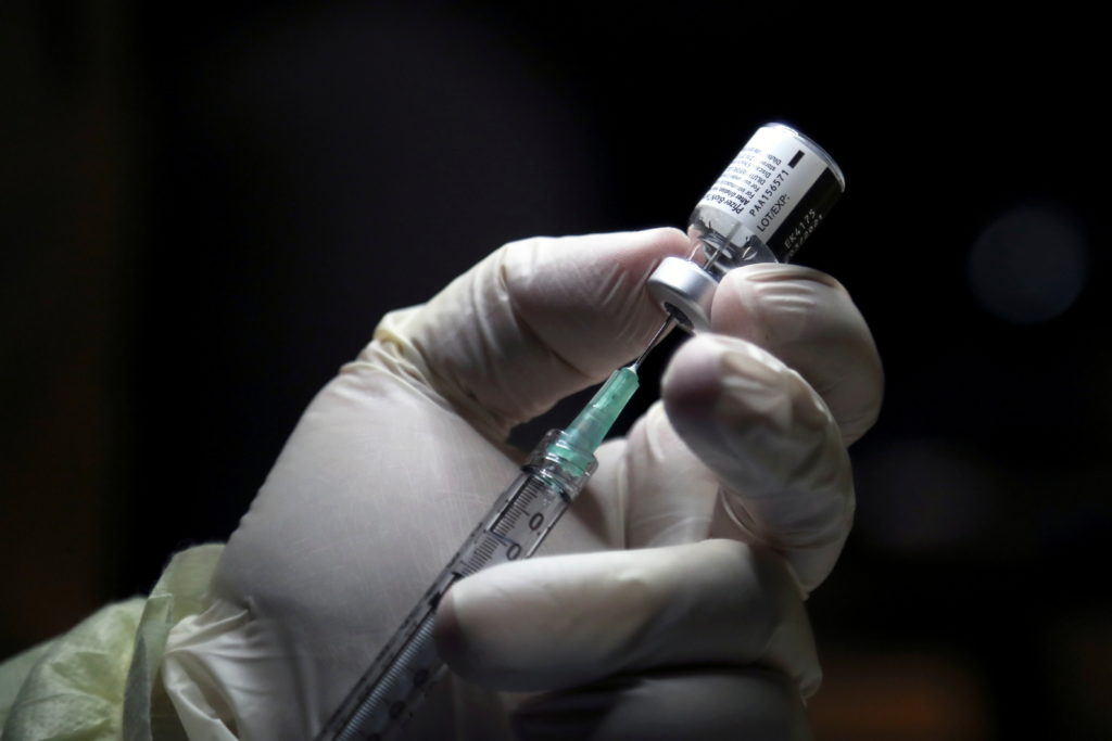 A healthcare worker prepares to administer a Pfizer/BioNTEch coronavirus disease (COVID-19) vaccine at The Michener Instit...