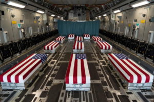 Flag-draped transfer cases line the inside of a C-17 Globemaster II prior to a dignified transfer