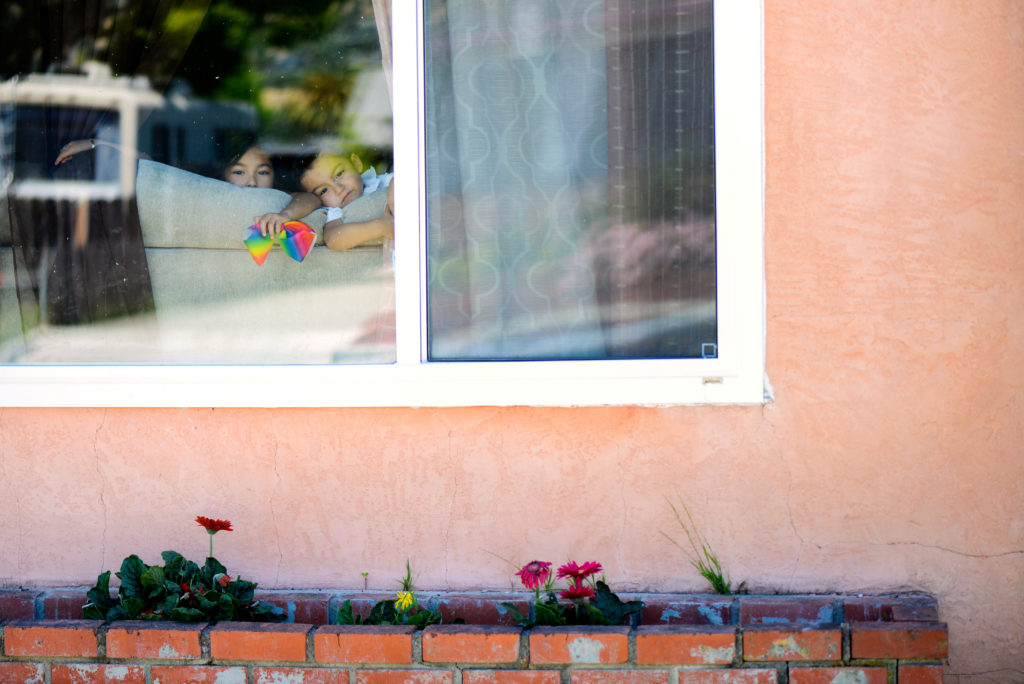 Mariscal siblings peer out of the window of the home where they were poisoned by lead-based paint in Hayward
