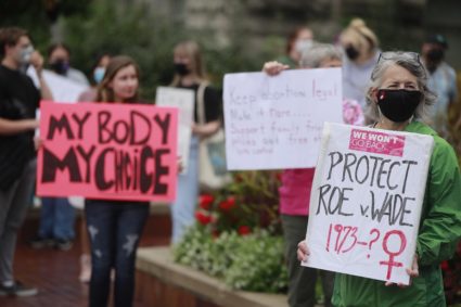 A woman holds a placard referring to Roe vs Wade as
