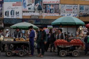 People buy fruits at a market in Kabul