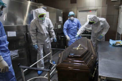 Employees of a funeral home and staff from Bucharest University Hospital morgue, all wearing personal protective equipment...