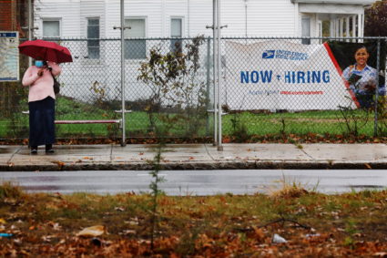 "Now Hiring" sign from the United States Postal Service hangs in Boston