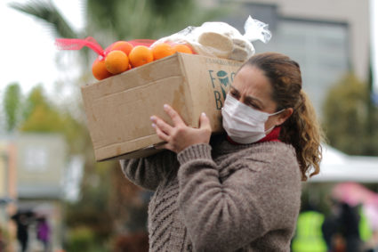 A woman picks up fresh food at a Los Angeles Regional Food Bank giveaway of 2,000 boxes of groceries, as the spread of the...