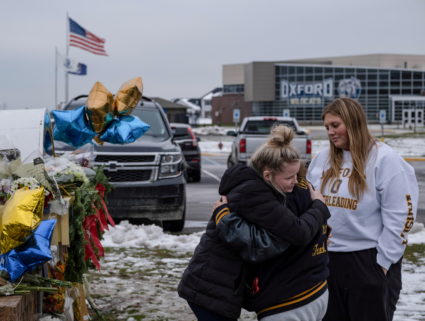 People pay their respects at a memorial at Oxford High School, a day after a shooting that left four dead and eight injure...