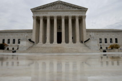 FILE PHOTO: The U.S. Supreme Court building is reflected on wet marble in Washington