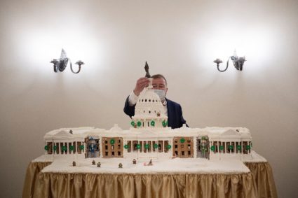 Fred Johnson III, the senior area manager of food operations for Sodexo in the U.S. House of Representatives, reattaches the Statue of Freedom to a gingerbread replica of the U.S. Capitol