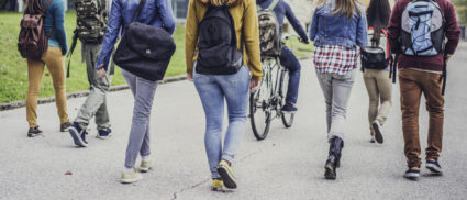 Group of unrecognizable sudents walking through the park