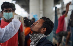 A health worker collects a swab sample from a man during a rapid antigen testing campaign for the coronavirus disease (COV...