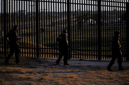 U.S. Border Patrol officers walk along the perimeter fence near the International Bridge between Mexico and the U.S., where migrants seeking asylum in the U.S. are waiting to be processed, in Del Rio, Texas, U.S., September 20, 2021. Photo by Marco Bello/REUTERS