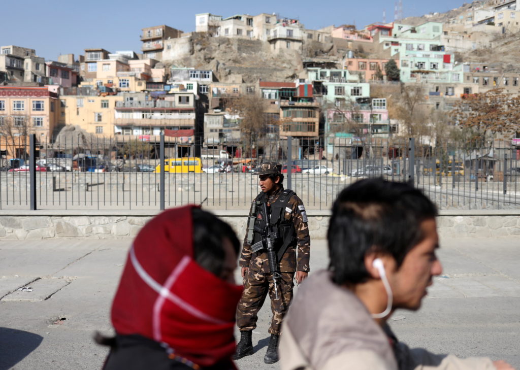 A Taliban fighter stands as he guards a checkpoint in Kabul, Afghanistan