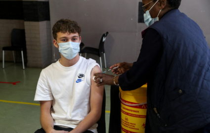 FILE PHOTO: A healthcare worker administers a dose of the Pfizer coronavirus disease (COVID-19) vaccine to a teenager, ami...