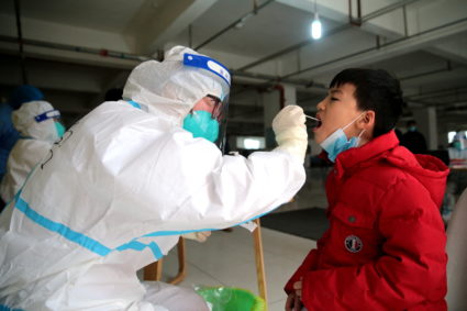 Medical worker collects a swab for nucleic acid testing following COVID-19 outbreak in Xian