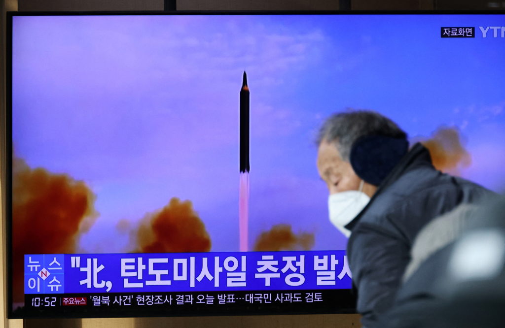 People watch a TV broadcasting file footage of a news report on North Korea firing a ballistic missile off its east coast ...
