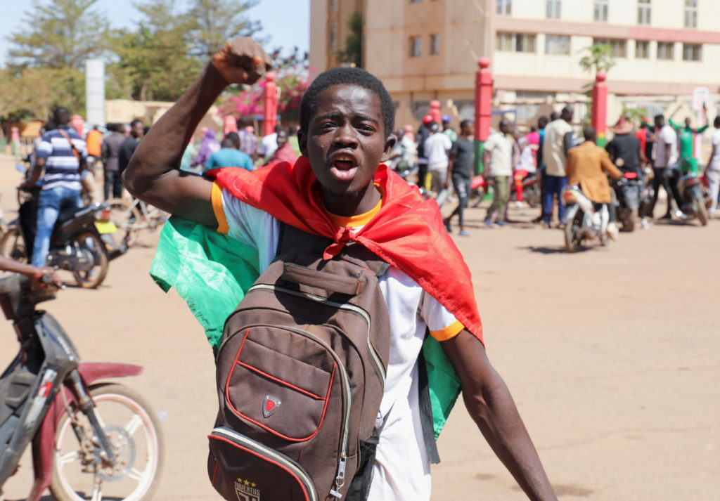 A teenager reacts as he shows support for the military after Burkina Faso President Roch Kabore was detained at a military...