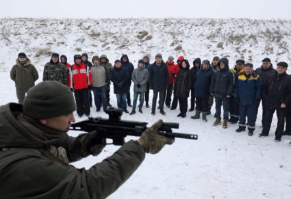 Employees of essential city industries and services attend a military training session outside Lviv