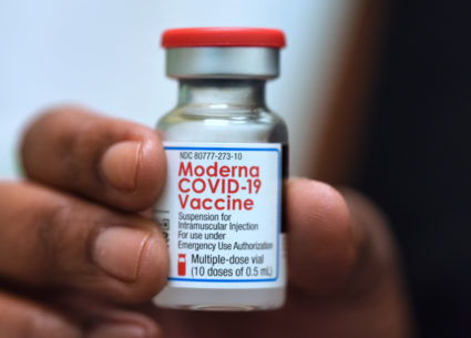 Dr. Salma Elfaki holds a vial of Moderna COVID-19 vaccine at