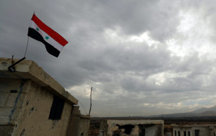 A Syrian flag is seen during an evacuation of rebels and civilians from Beit Jann, in Mogher al-Meer village