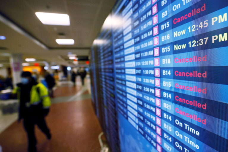 A board displays the status of flights to and from Logan International Airport in Boston