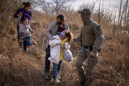 Asylum seeking migrants are escorted out of the brush after crossing Rio Grande river into the U.S. from Mexico in Penitas...