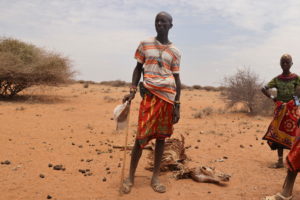 Bargeri, a herdsman from the Rendille ethnic group, stands next to the carcass of his donkey who died due to an ongoing dr...
