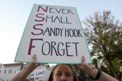 Karen Perrone holds a sign during a solidarity vigil in memory of victims of Las Vegas' Route 91 Harvest music festival ma...