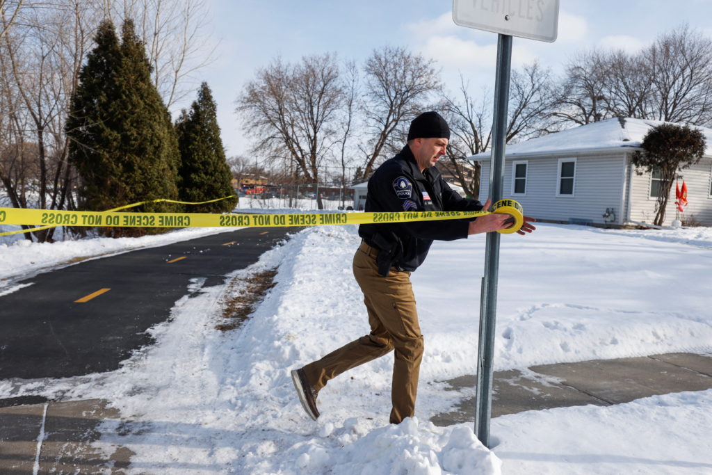 A police officer tapes off the surrounding area as officials respond to a shooting outside of the South Education Center s...