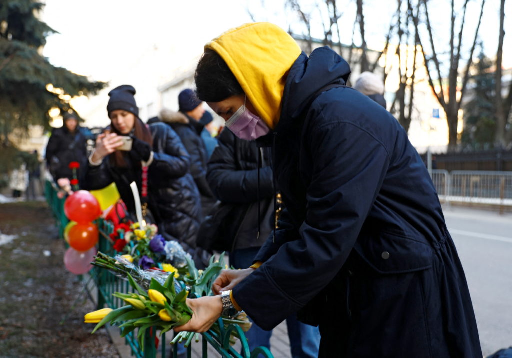 A woman places flowers outside the Ukrainian embassy in Moscow