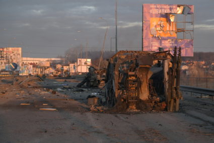 Charred military vehicles are seen on a road near Bucha