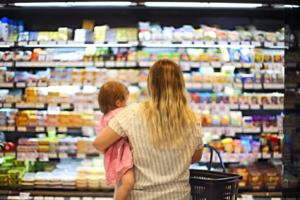 Cheerful mother and baby spending time in shopping in supermarket