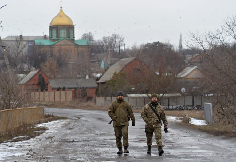 Service members of the Ukrainian armed forces walk at combat positions in Donetsk region