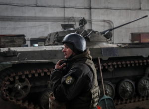 Ukrainian service member stands near an infantry fighting vehicle on the front line near the city of Novoluhanske