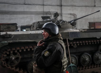 Ukrainian service member stands near an infantry fighting vehicle on the front line near the city of Novoluhanske
