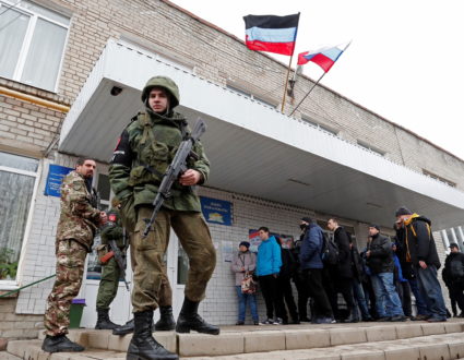 Militants of the self-proclaimed Donetsk People's Republic stand outside a military mobilization point in the separatist-c...