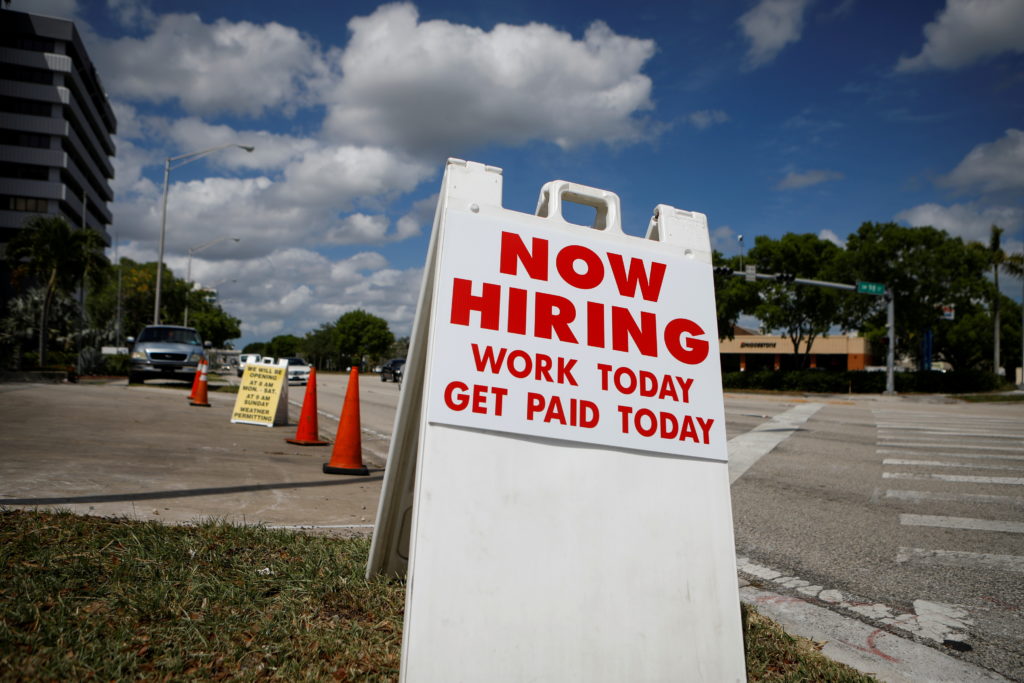 A "Now Hiring" sign advertising jobs at a hand car wash is seen along a street in Miami, Florida, U.S. May 8, 2020. Photo ...