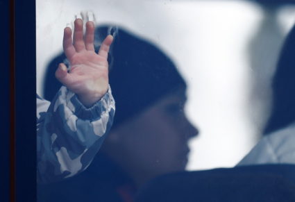 The hand of a child is seen through a bus window at a temporary accommodation centre, after fleeing Russian invasion of Ukraine, in Korczowa, Poland, March 3, 2022. Photo by Yara Nardi/REUTERS