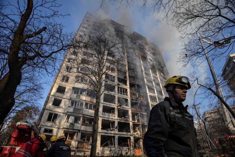 Firefighters work to put out a fire in a residential apartment building after it was hit by shelling in Kyiv