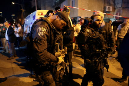 Israeli border police walk through the scene of a fatal shooting attack on a street near Tel Aviv