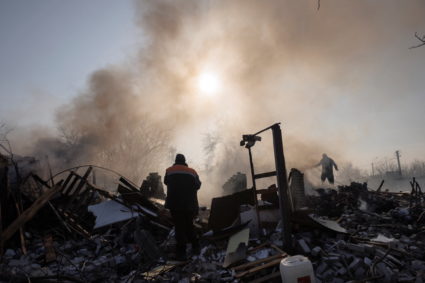Residents extinguish a fire after a bombing destroyed a family home in a northern district of Kharkiv as Russia's attack o...